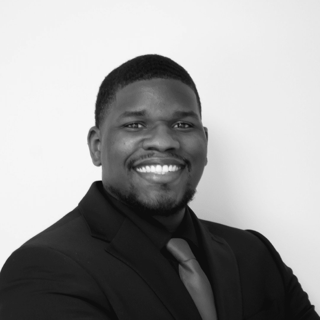 Smiling man in suit with crossed arms.