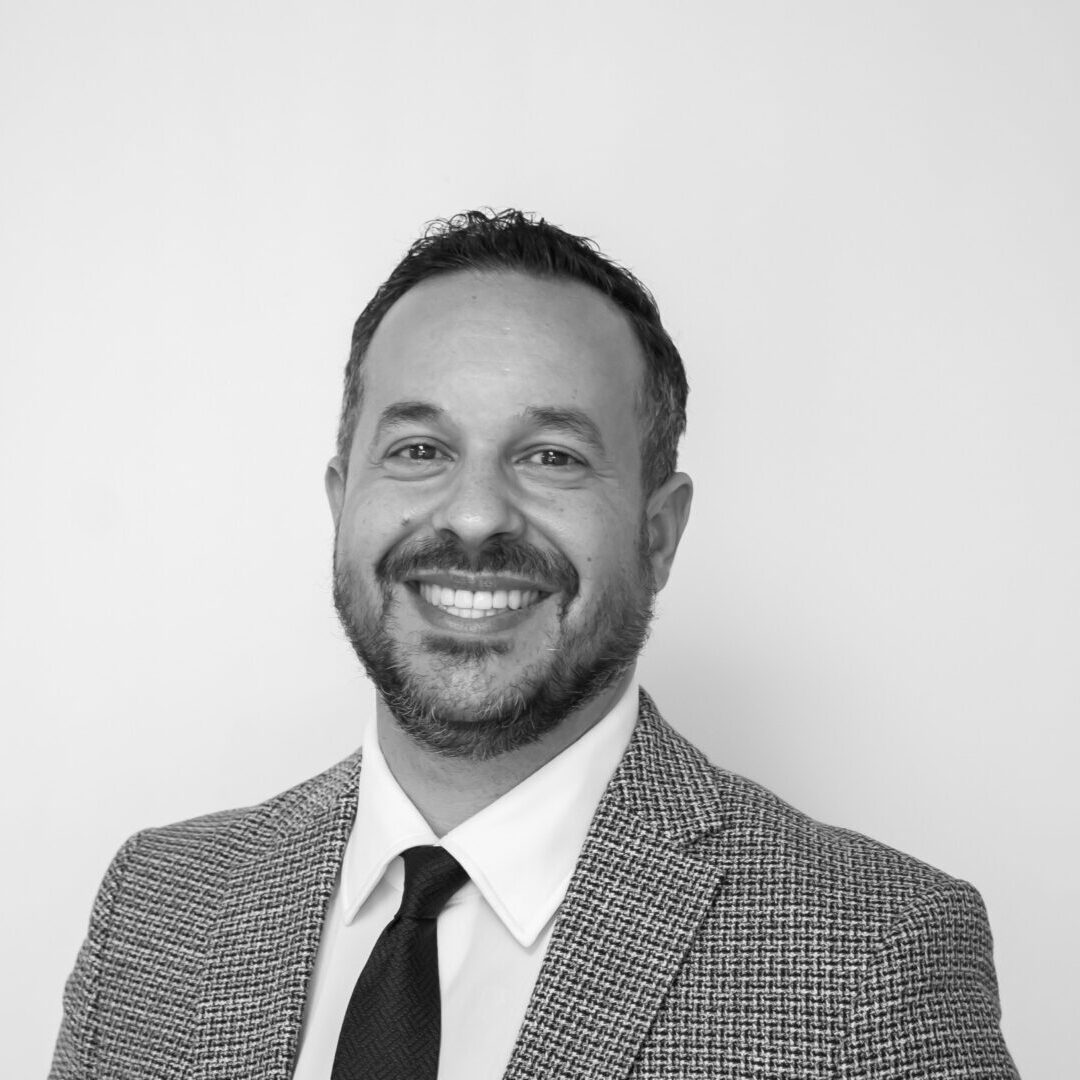Smiling man in suit, monochrome portrait.